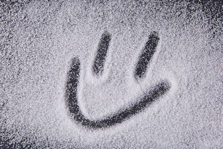 8-written-by-a-finger-smiley-icon-on-the-texture-of-white-sugar-crystals-on-the-black-background.jpg